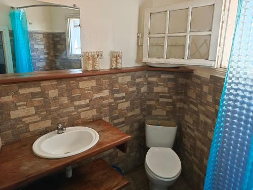 a bathroom with a sink and a toilet and a mirror at Le Réverbère in Antananarivo