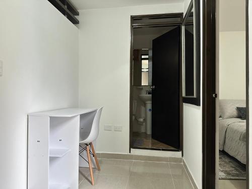 a room with a white desk and a bed and a mirror at Apartamento 301 Edificio Natura 54 in Ibagué