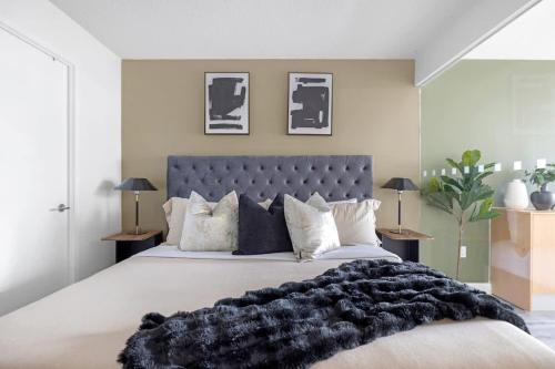 a bedroom with a large bed with a black blanket at Luxury Waterfront Escape Stylish 3BR Condo in Toronto