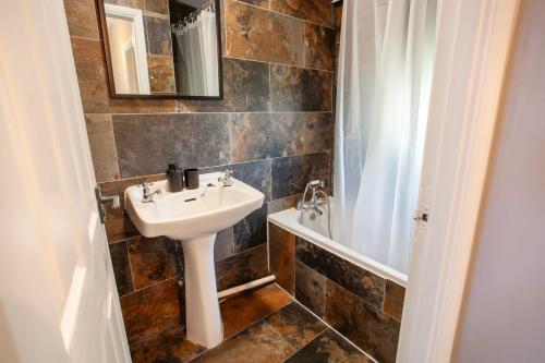 a bathroom with a sink and a toilet and a tub at 3Bed House in Hatfield in Hatfield