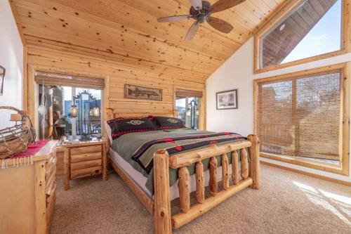 ein Schlafzimmer mit einem Bett in einer Blockhütte in der Unterkunft Pegasus Luxe Mnt Retreat Stunning Views & Hot Tub in Big Bear Lake