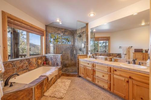 ein Badezimmer mit zwei Waschbecken, einer Badewanne und einer Dusche in der Unterkunft Pegasus Luxe Mnt Retreat Stunning Views & Hot Tub in Big Bear Lake