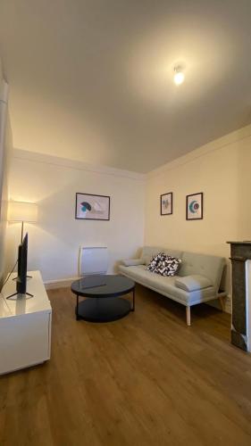 a living room with a couch and a table at Le Béarnois - 3 Chambres - Myra Conciergerie in Pau