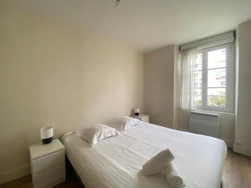 a white bedroom with a white bed and a window at Le Béarnois - 3 Chambres - Myra Conciergerie in Pau