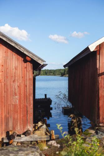 a couple of buildings sitting next to a body of water at Summer house for the whole family in Öregrund