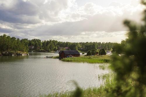 a lake with a house and a barn in the middle at Summer house for the whole family in Öregrund