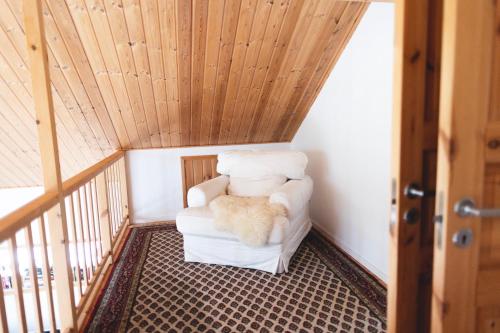 a white chair in a room with a wooden ceiling at Summer house for the whole family in Öregrund