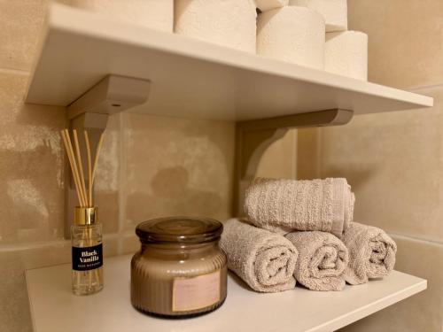 a shelf with towels on it with a jar ofented at Cosy 1-Bedroom Apartment with Private Terrace in Loulé in Loulé