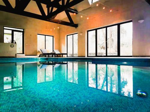 a large swimming pool in a building with windows at EXCL HOUSE in Warsaw with POOLS in Józefów