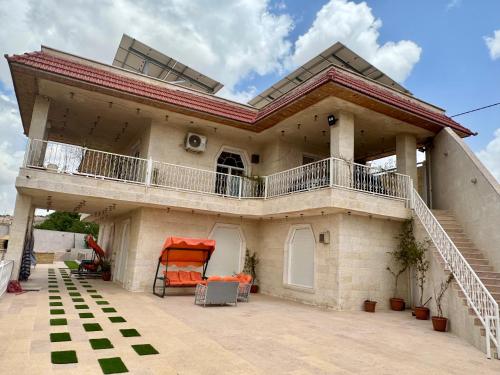 a large house with a balcony on a patio at مزرعة وشالية هوى الوادي 
