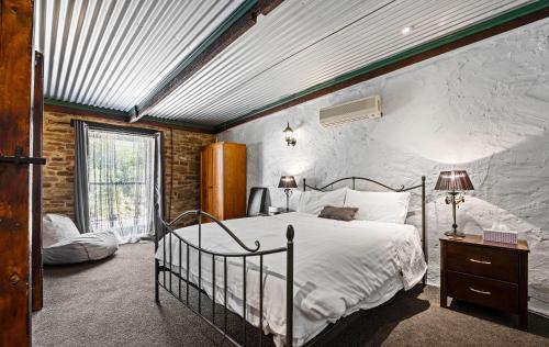 una camera da letto con un letto grande in una stanza di Barossa Valley Springton Cottages a Springton