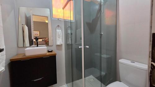 a bathroom with a glass shower and a toilet at Kitnet próxima da USP, CPO e USC in Bauru
