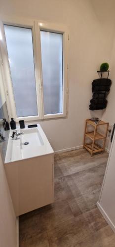 a bathroom with a sink and two windows at Urban Tribu Saumur Centre Parking facile 6 p in Saumur