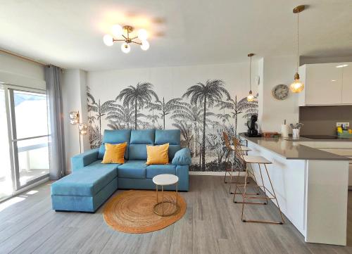 a living room with a blue couch and a kitchen at El mirador de La Concha in Oropesa del Mar