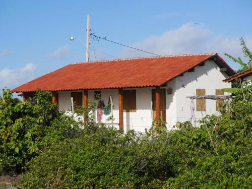 a white house with a red roof at Loft 1 - Casa Aratu Guaiú Barra de Mamanguape in Rio Tinto