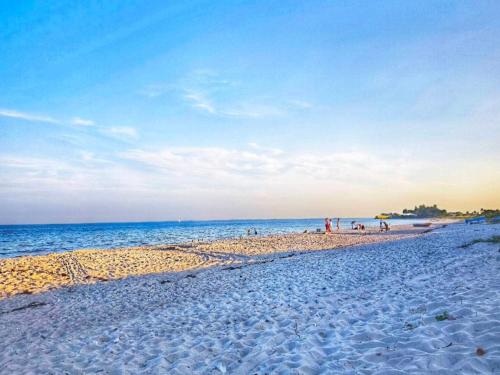 a group of people on a beach near the water at 4 star holiday home in Sydals-By Traum in Neder Lysabild