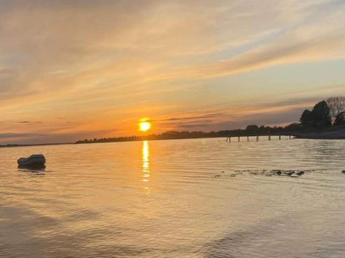 a sunset over a body of water with a boat at 6 person holiday home in Sydals-By Traum in Østerby