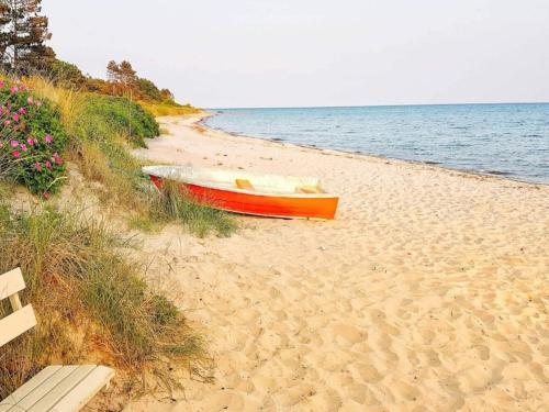 a boat sitting on a beach next to the water at 6 person holiday home in Sydals-By Traum in Østerby