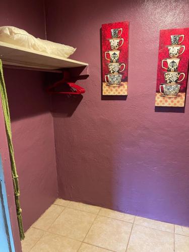 a room with three pictures on a purple wall at Southern Perk -Coffee & Caffeine in Crestview