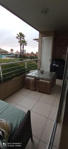 a balcony with a table and a view of the ocean at Hermoso Departamento Algarrobo in Algarrobo