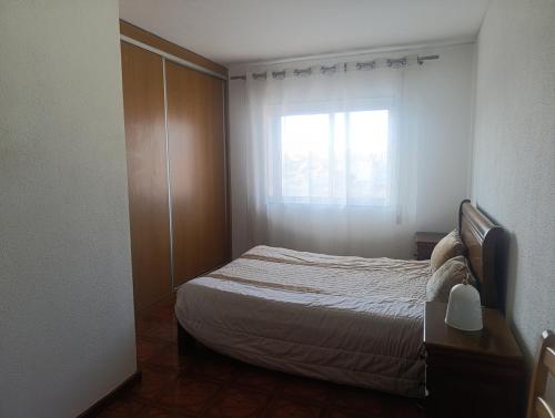 a small bedroom with a bed and a window at Apartamento T2 Vista mar in Vila do Conde