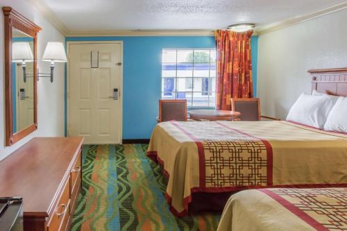 a hotel room with two beds and a window at Days Inn by Wyndham Virginia Beach Town Center in Virginia Beach