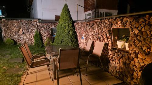a patio with a table and chairs next to a stone wall at Alpine Yard Nest Busteni in Buşteni