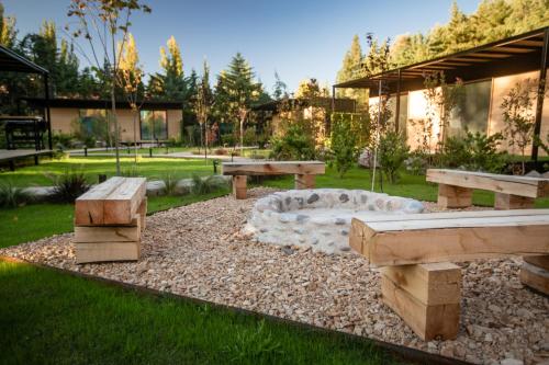 a park with benches and a table in the grass at Huellas de Chacras in Ciudad Lujan de Cuyo