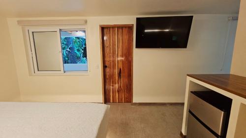 a bedroom with a bed and a window and a television at Dreamcatcher Luxury in Santa Teresa Beach