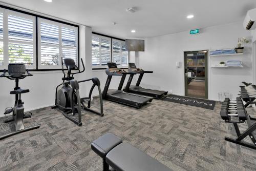 a gym with treadmills and exercise bikes in a room at The Palmer Collective in Townsville