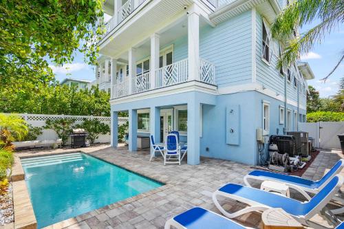 a house with a swimming pool and lounge chairs at Heated Pool Elevator Game Room & Ocean Decks in Coquina Gables