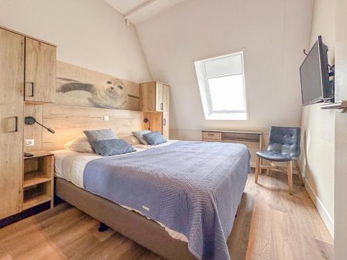 a bedroom with a large bed with blue pillows at Top luxe 27G in Colijnsplaat