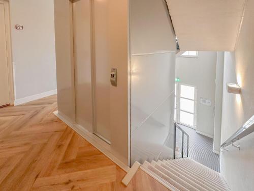 a glass elevator in a room with a wooden floor at Top luxe 27G in Colijnsplaat
