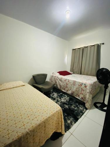 a room with two beds and a chair in it at Casa para a COP 30 in Castanhal