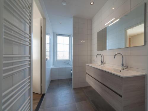 a bathroom with a large sink and a tub at SeaLuxe Residence in Colijnsplaat