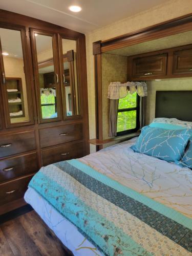 a bedroom with a bed and a large window at Aberdeen Hillview Retreat in Whycocomagh