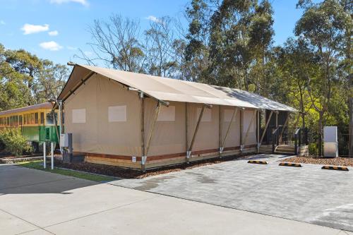 a building with a tent in a parking lot at BIG4 Yarra Valley Park Lane Holiday Park in Healesville