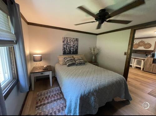 Un dormitorio con una cama y un ventilador de techo. en The Cozy Nest, en Mount Airy