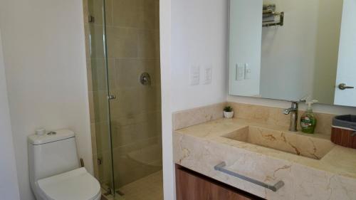 a bathroom with a toilet and a sink and a shower at Modern, with Ocean and Mountain View in Puerto Vallarta