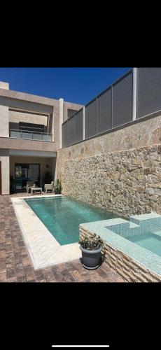 a house with a swimming pool in front of a building at Villa - Djerba in Midoun