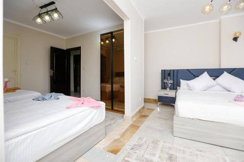 a bedroom with two beds and a glass door at three pyramids view & jacuzii in Cairo