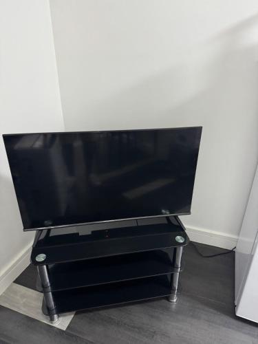 a flat screen tv sitting on a black stand at One bed flat in Northampton