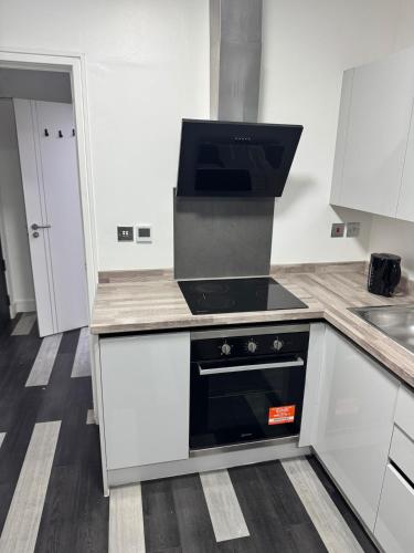 a kitchen with a black stove top oven at One bed flat in Northampton