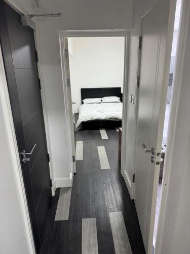 a hallway leading to a bedroom with a bed at One bed flat in Northampton