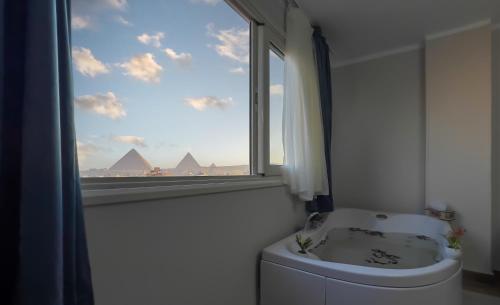 a bathroom with a window and a toilet and a sink at Giza pyramids view & jacuzii in Cairo