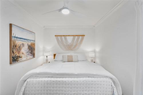 a white bed in a white bedroom with a window at Barefoot Boho- Beach bungalow on Anna Maria Island in Bradenton Beach