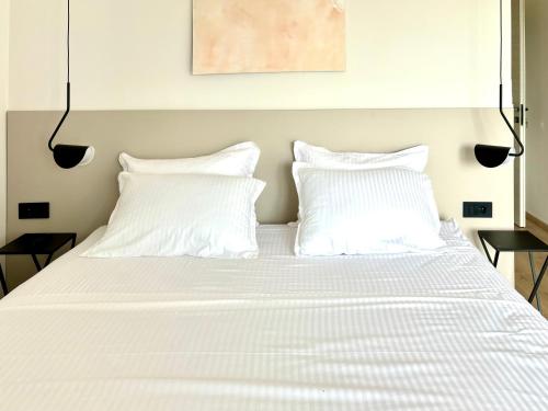 a bed with white sheets and pillows on it at White Villa, Brac in Splitska