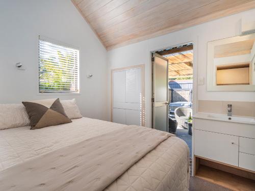une chambre avec un lit et un lavabo dans l'établissement Living The Dream - Matarangi Holiday Home, à Whitianga