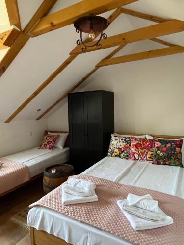a attic room with two beds and a table at Apartments PKT DeLux in Niš