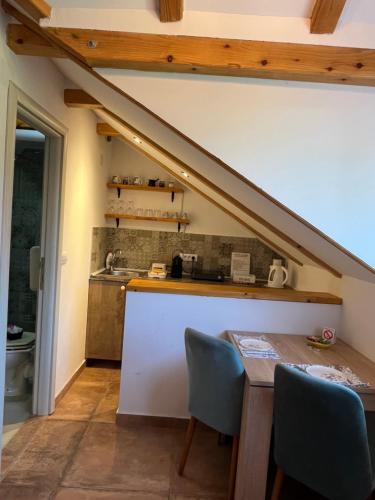 a kitchen with a sink and a table with chairs at Apartments PKT DeLux in Niš